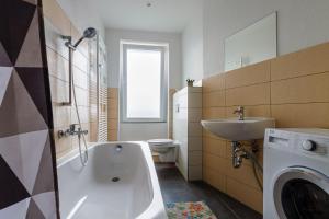 a bathroom with a tub and a sink and a toilet at Moderne Monteurwohnung in Leipzig Nord in Leipzig