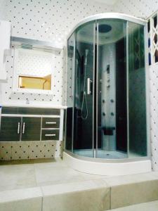 a bathroom with a glass shower with a mirror at City Stay lodging center in Botianaw