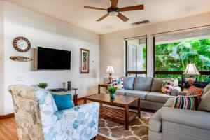 a living room with a couch and a tv at Tropical Getaway at the Shores Waikoloa Beach #138 in Waikoloa