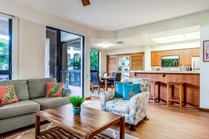 a living room with a couch and a table at Tropical Getaway at the Shores Waikoloa Beach #138 in Waikoloa