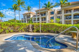 a resort with a swimming pool and a building at Tropical Getaway at the Shores Waikoloa Beach #138 in Waikoloa