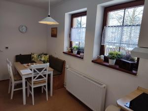 a living room with a table and chairs and windows at Apartmán FuFu in Prostřední Lánov