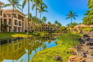 a resort with palm trees and a body of water at Tropical Getaway at the Shores Waikoloa Beach #138 in Waikoloa