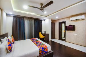 a bedroom with a bed and a desk and a tv at FabHotel Prime Kzar Corporate in Kolkata