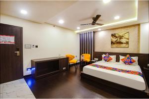 a bedroom with a bed and a flat screen tv at FabHotel Prime Kzar Corporate in Kolkata