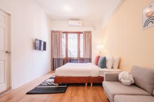 a bedroom with a bed and a couch at House Of Papa Bangkok Siam in Bangkok