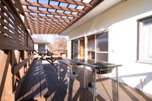 a glass table on a deck with a wooden ceiling at Bell-Rental Villa Engawa House in Fujikawaguchiko