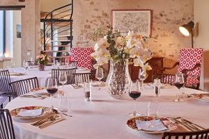 a long table with a vase of flowers on it at Chambre d'hôtes Les Herbes Folles in Mauregard +11 photos