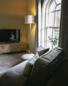 ein Wohnzimmer mit einem Sofa und einem großen Fenster in der Unterkunft Walshford Lodge in Cowthorpe