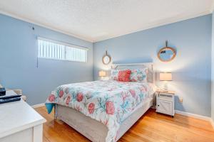 a bedroom with a bed with a floral bedspread and two lamps at Van Lee 1003 in Ormond Beach
