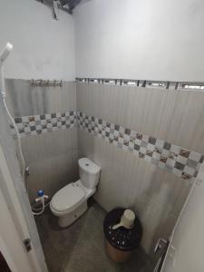 La petite salle de bains est pourvue d'une douche et de toilettes. dans l'établissement Kost or Pasutri Rooftop Pogung Dalangan Sleman, à Kejayan