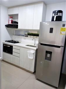 cocina con nevera de acero inoxidable y fregadero en Acogedor, Gran Vista a las Montañas y a la Ciudad! en Santa Fe de Antioquia