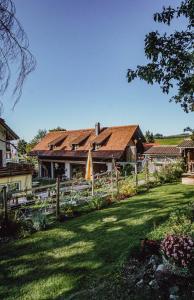 ein Haus mit einem Zaun vor einem Hof in der Unterkunft Gasthaus Hirsch in Wangen im Allgäu