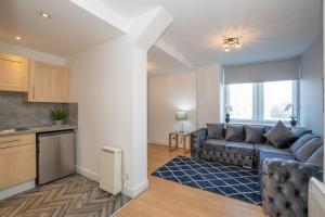 a living room with a couch and a kitchen at Tiramisu House - Luxury 2 Bed Apartment in Aberdeen Centre in Aberdeen