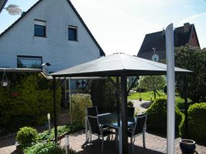 a table and chairs under an umbrella in front of a house at Ferienbungalow Meerjungfrau im Seebad Ueckermünde in Ueckermünde