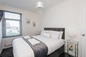 a white bedroom with a large bed with white pillows at Pease Street in Darlington