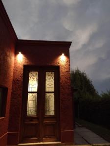 a door with two windows on a brick building at Puerta 1910 in Tunuyán