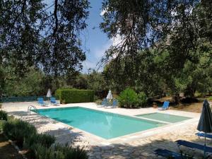 een zwembad in een tuin met stoelen en een boom bij Villa Stefanos Apartments by Hotelius in Glyfa