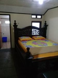 1 dormitorio con 1 cama grande y cabecero de madera en Villa Borobudur Malino, 