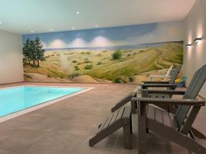 une piscine avec des chaises et une fresque murale dans l'établissement Ferienhof Marquardt Fewo Mohnblume, à Wenkendorf
