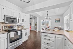 a white kitchen with white cabinets and a kitchen island at The Americana in Bella Vista