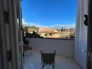 einen Balkon mit einem Stuhl und Stadtblick in der Unterkunft CAMERE private in Porto Azzurro