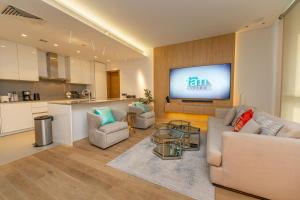 a living room with a couch and a tv on a wall at FAM Living - City Walk - Luxe Interiors in Dubai