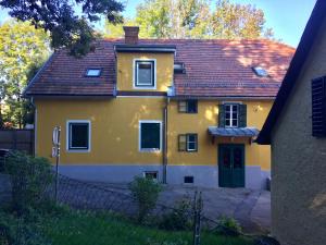 een geel huis met een rood dak bij Apartment Graz-Ulrichsbrunn, free parking in Graz