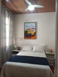 a bedroom with a bed with a painting on the wall at Apartamento copacabana Beach in Rio de Janeiro