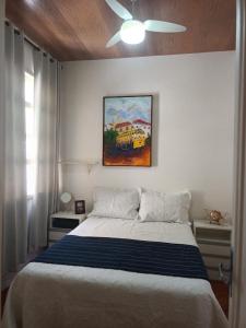 een slaapkamer met een bed met een schilderij aan de muur bij Apartamento copacabana Beach in Rio de Janeiro