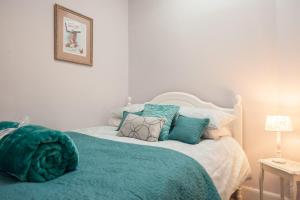 a bedroom with a bed with blue pillows at The Distillers Den in Oban