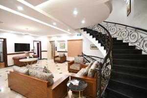a living room with a spiral staircase and a living room at Royal Regency Hotel in Islamabad
