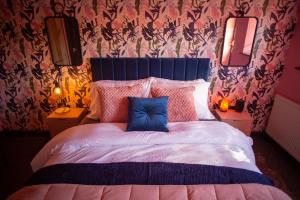 a bedroom with a bed with a blue pillow on it at The Stables - Quirky one bed holiday home with wood fired hot tub in Rudston