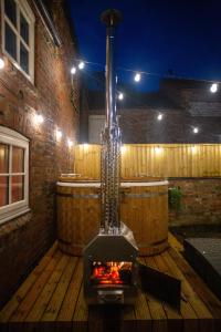 a outdoor fireplace on a wooden deck at night at The Stables - Quirky one bed holiday home with wood fired hot tub in Rudston