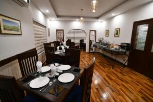 - une salle à manger avec une table et des chaises dans l'établissement Royal Regency Hotel, à Islamabad