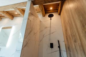 a bathroom with a marble wall and wooden ceilings at Vila Cornelia in Banská Štiavnica