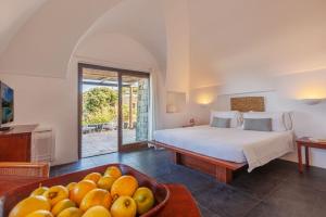 Pantelleria Dream Resort في بانتيليريا: غرفة نوم بسرير وصحن فواكه