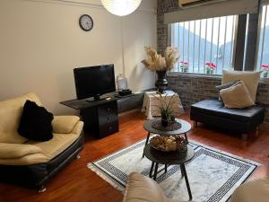 a living room with a couch and a tv at Lovely Cozy Apartment in the entrance of Nicosia in Aglantzia