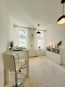 um quarto branco com uma secretária e uma cadeira em Gemütliches helles Appartement em Dresden
