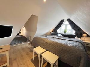 ティンヌムにあるFriesenhaus 'Inselherz'のベッドルーム1室(ベッド1台、スツール2台、テレビ付)