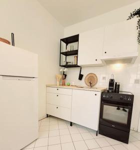 a kitchen with a black stove and white cabinets at Gemütliches helles Appartement in Dresden