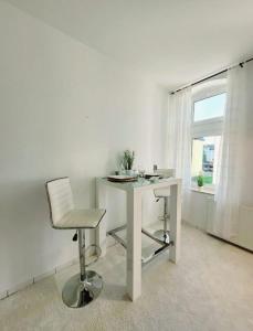 escritorio blanco y silla en una habitación con ventana en Gemütliches helles Appartement en Dresden