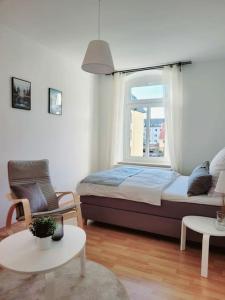 a bedroom with a bed and a window and a chair at Gemütliches helles Appartement in Dresden