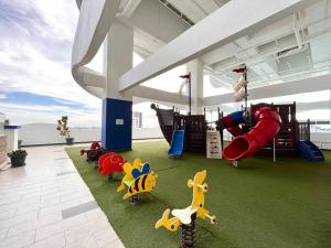 uma área recreativa com um parque infantil com um escorrega em Concept Suite 05 @ The Wave Residence em Tranquerah