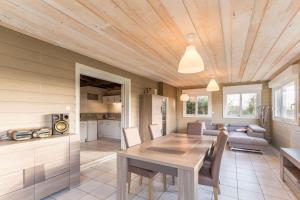 een keuken en eetkamer met een houten plafond bij Le cocon d'Aurore 