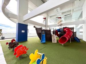 uma sala de jogos com um parque infantil com um escorrega em Concept Suite 05 @ The Wave Residence em Tranquerah