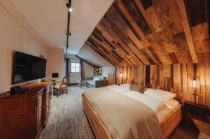 a bedroom with a large bed and a flat screen tv at Hotel LÜ - Adults Only in Obertauern