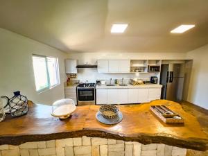 a kitchen with a wooden table in the middle of it at Casa das Flores in Barra Grande +4 photos