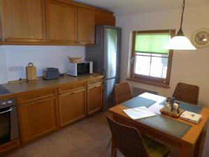 een keuken met een tafel en een eetkamer bij Schöne helle Ferienwohnung in Eurasburg