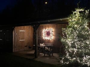Uma coroa de Natal, uma mesa e uma árvore de Natal. em Cabin Margot with hot tub in private garden em Kaprijke